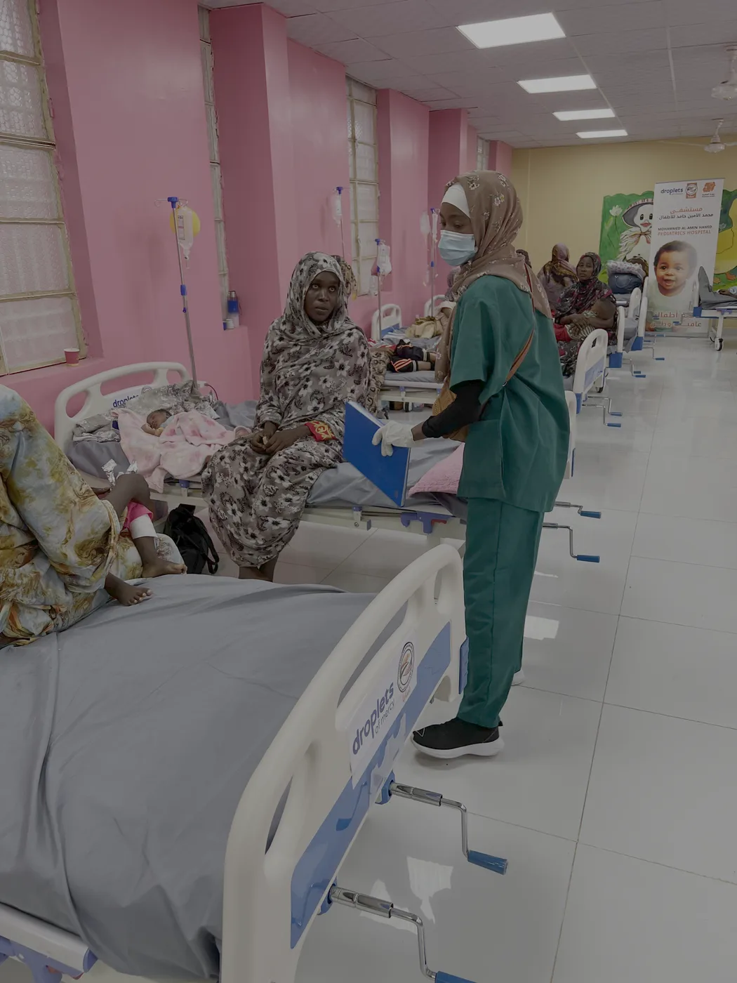 A nurse in scrubs caring for patients in the Droplets of Mercy funded ward in Sudan